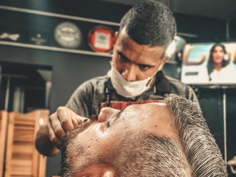 A barber styling and finishing a client’s hair in the Blackwood Barbers shop
