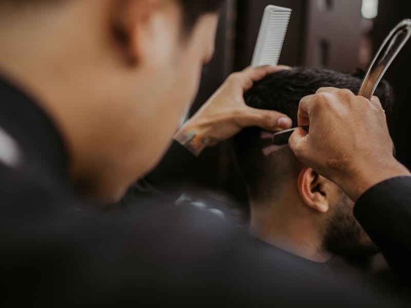 A styled pompadour haircut with a clean taper at the sides